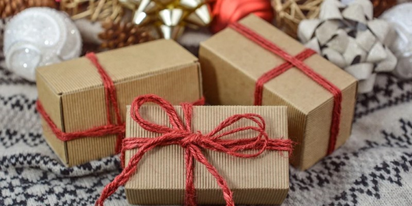 Recyclable cardboard gift packaging wrapped in red ribbon